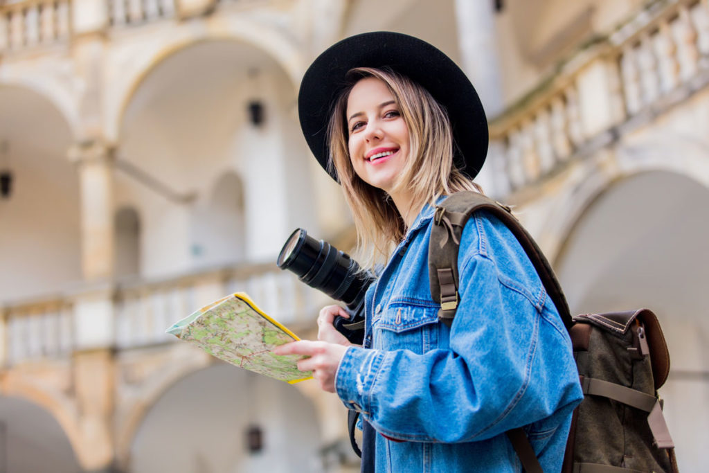 travel photographer holding map of city and camera