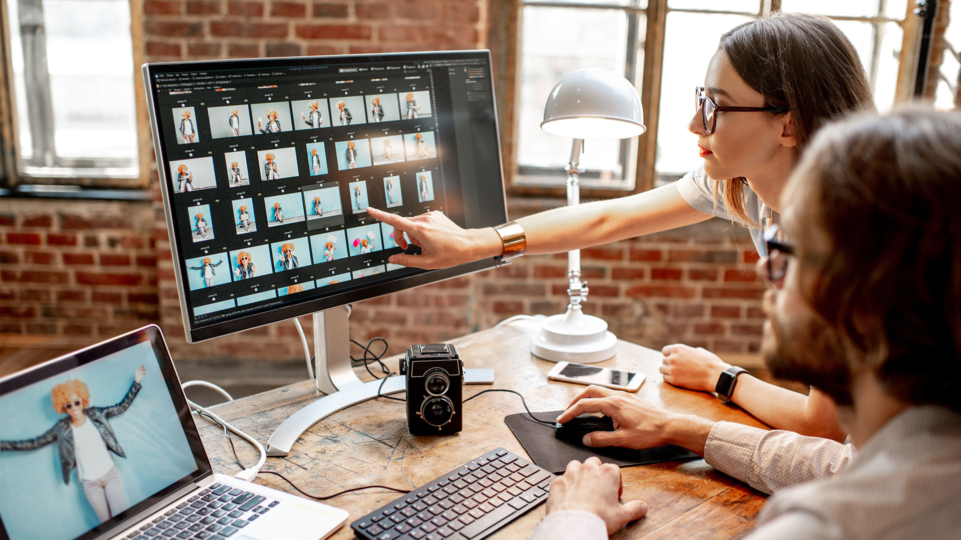 two photographers editing photos on computer