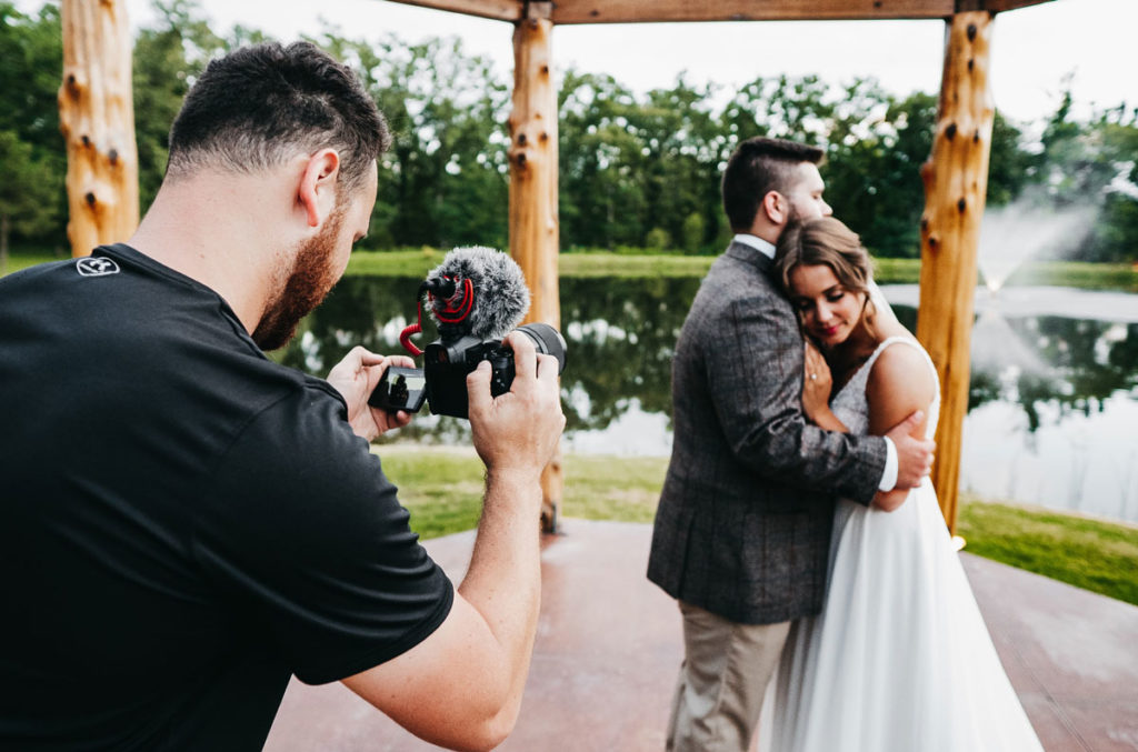 Wedding videographer taking video of happy couple