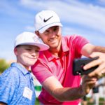 Golf pro taking image with younger golfer on the golf course