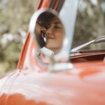 Couple kissing in car, image taken of their car mirror