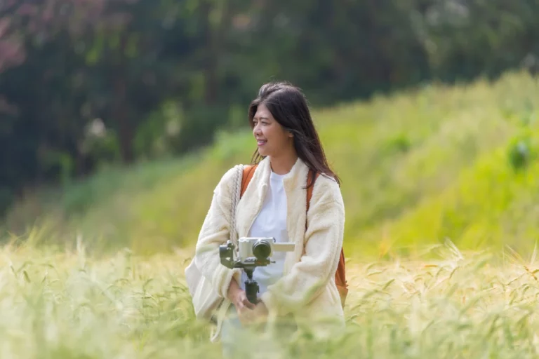 A nature videographer setting up in a field.