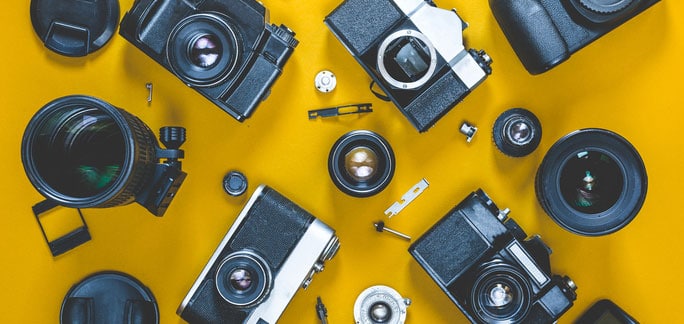 picture of several cameras on yellow background
