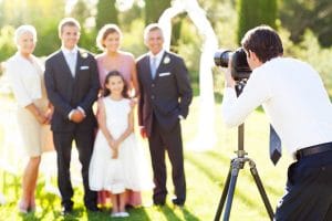 family at a wedding with photographer taking photos