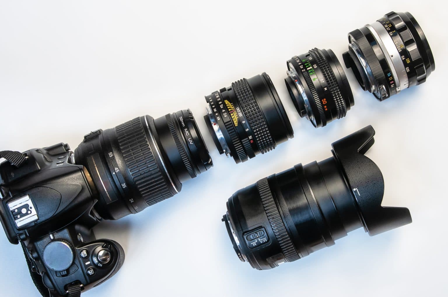camera and photo lenses on white background. Concept of interchangeable lenses and optics. Flat lay, top view.