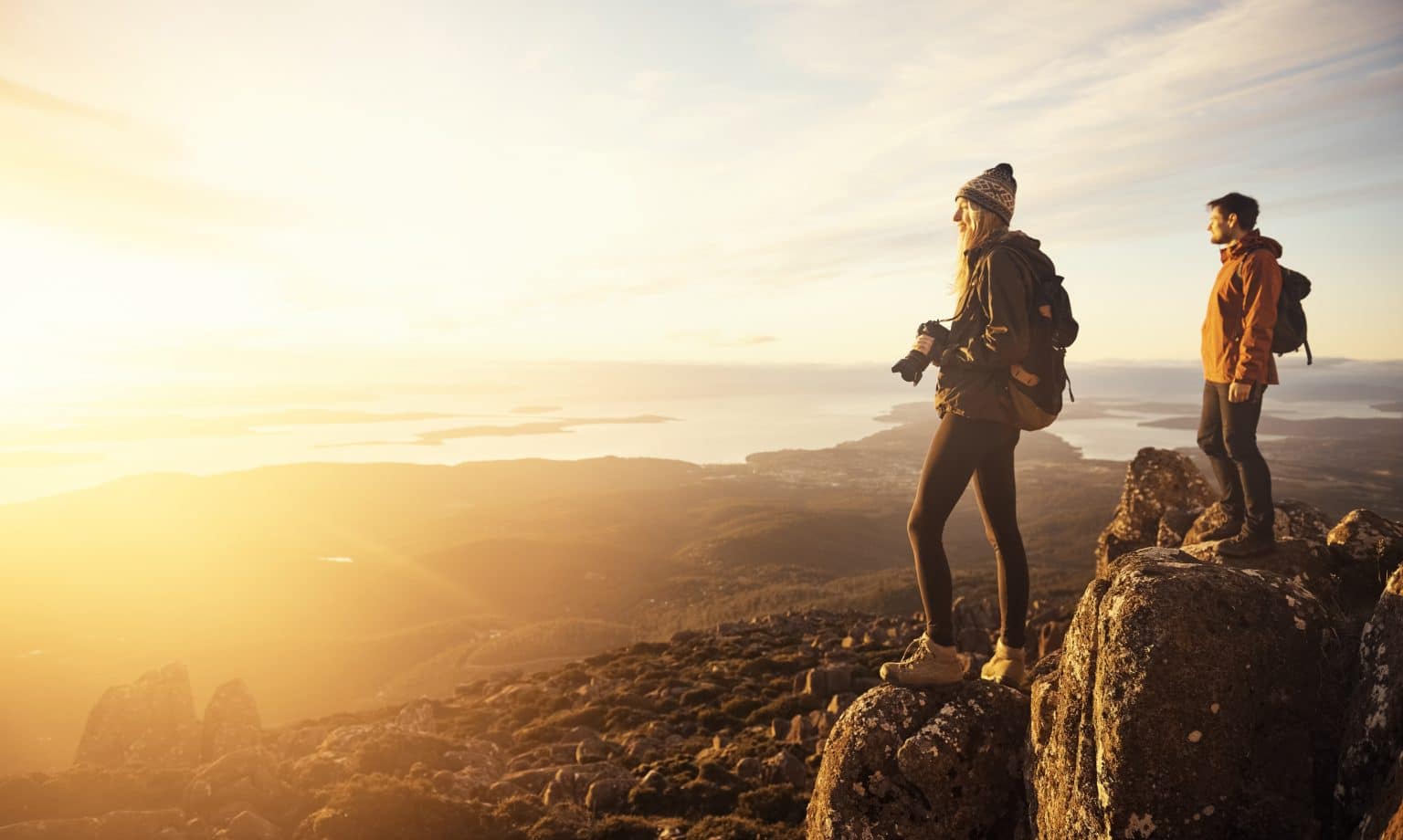 Shot of a young couple taking pictures from the top of a mountain