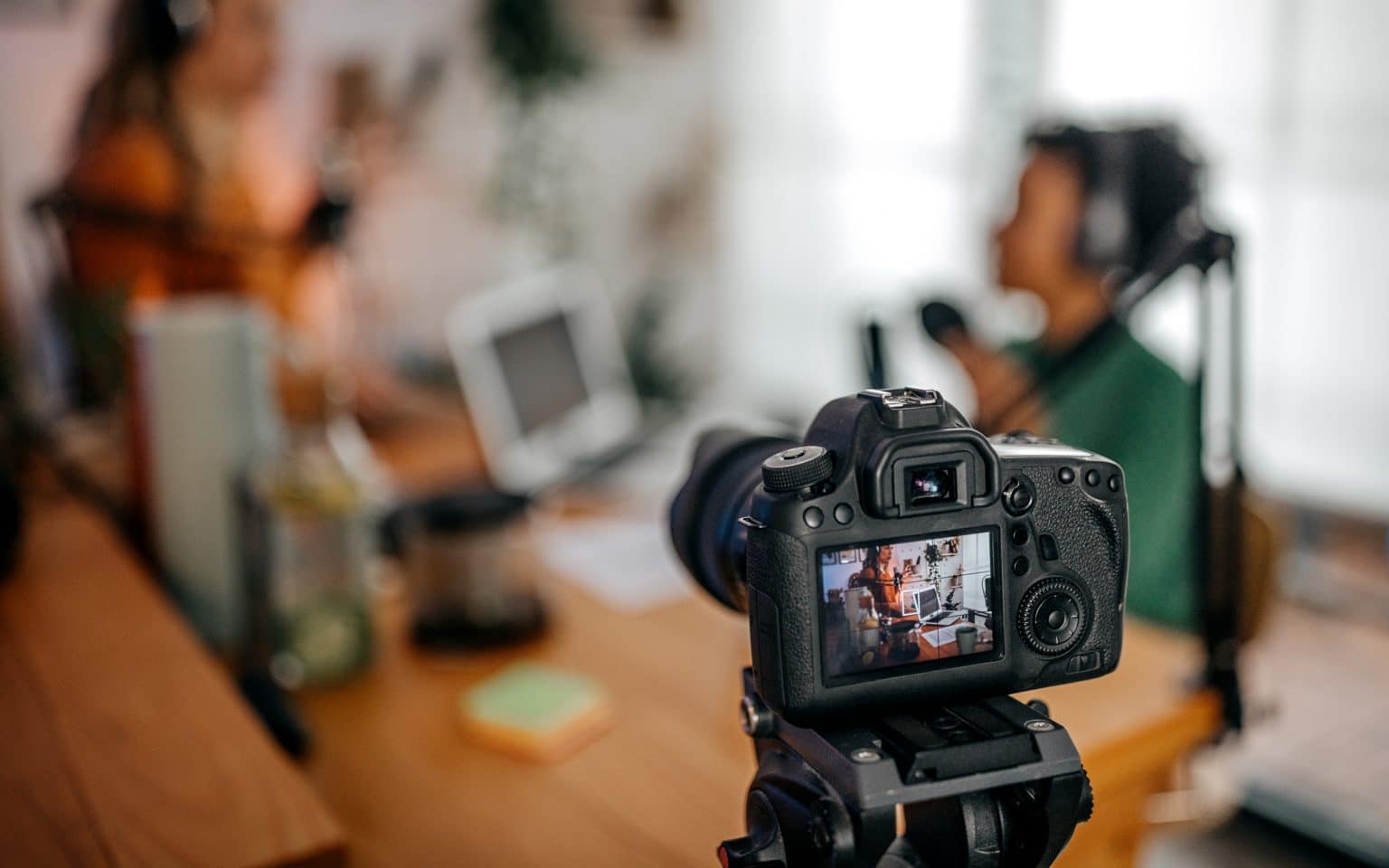 Close-up of a digital camera recording a podcast show in studio with unrecognized two women