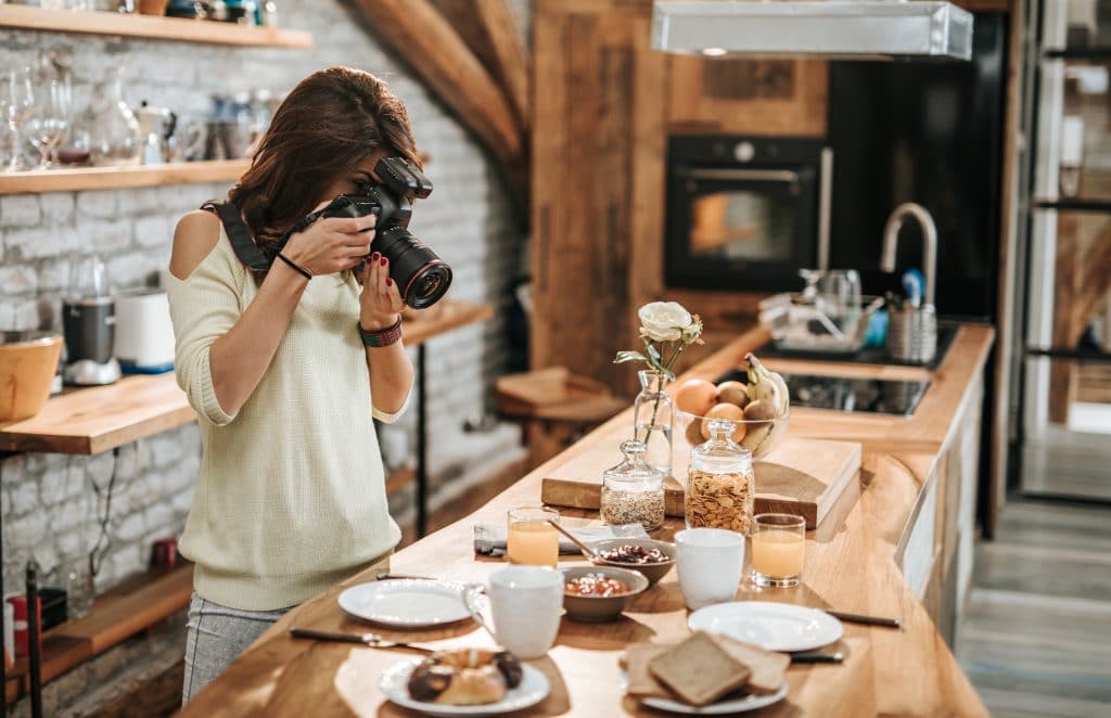 photographer taking photos of food at dining table.