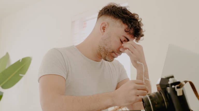 Shot of a young man feeling stressed while working on a photography project at home