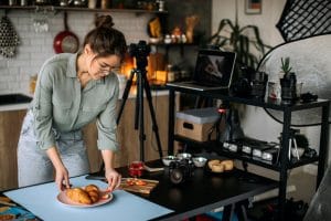 Young female food photographer setting everything up for shooting