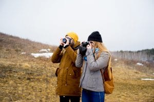 Two photographers hiking on a mountain lake
