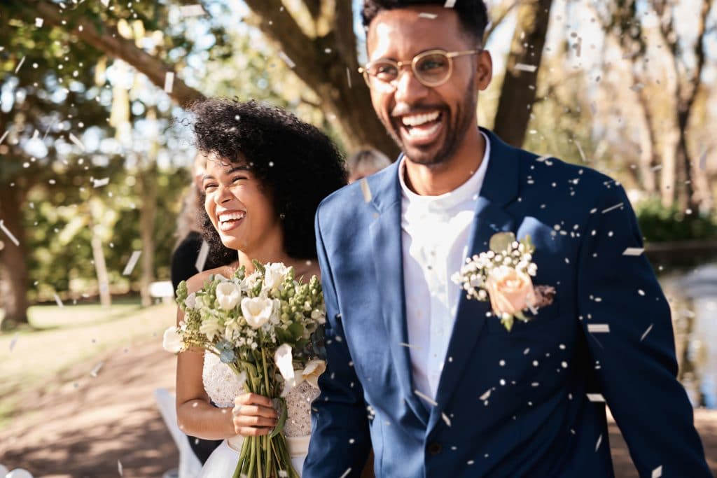 newlywed young couple getting showered with confetti